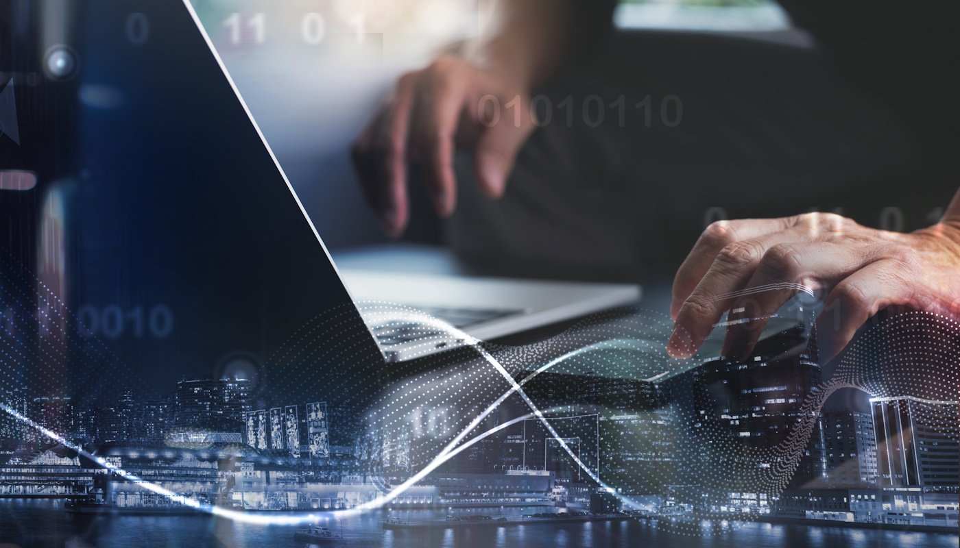 Close-up of hands typing on a laptop with a digital overlay of binary code and a city skyline, representing high-speed broadband connectivity and data transmission.